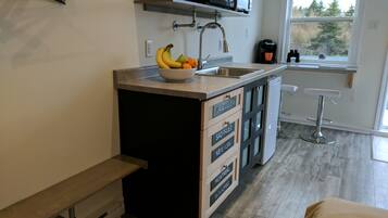 Una cocina moderna con una isla central, un lavamanos integrado y un microondas sobre la encimera.