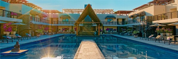 A pool area with lounge chairs and a central water feature.