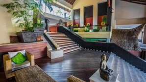A modern interior with a staircase, wooden furniture, and decorative plants.