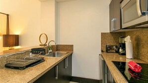 A modern kitchen with granite countertops, stainless steel appliances, and a built-in oven. - Aldea Thai 35 by Tripintravel (Playa del Carmen)