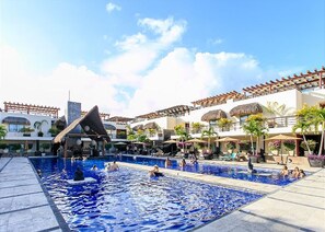 A resort pool area with multiple pools and a central water feature. - Aldea Thai 01 by Tripintravel (Playa del Carmen)