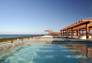 A clear pool with a wooden deck and a view of the ocean. - Aldea Thai 10 by Tripintravel (Playa del Carmen)