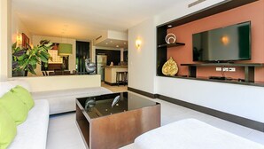 A modern living room with a sofa, a coffee table, and a TV mounted on the wall. - Aldea Thai 32 by Tripintravel (Playa del Carmen)