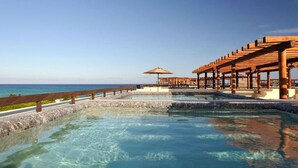 A clear pool with a wooden deck and a view of the ocean. - Aldea Thai 27 by Tripintravel (Playa del Carmen)