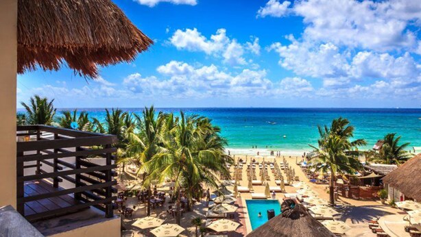 A beach resort with a pool, palm trees, and a thatched-roof building. - Aldea Thai 27 by Tripintravel (Playa del Carmen)