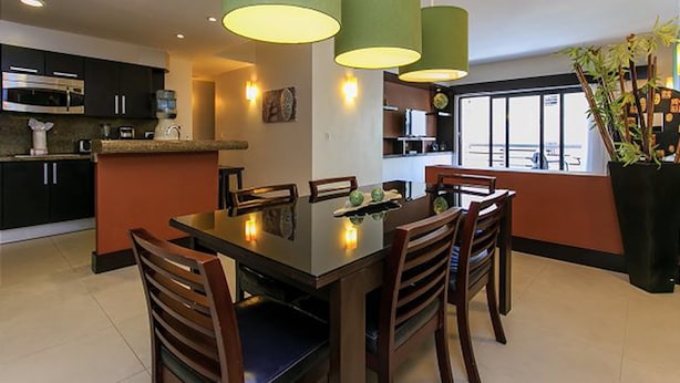 A modern kitchen with a dining table, chairs, and pendant lights. - Aldea Thai 12 by Tripintravel (Playa del Carmen)