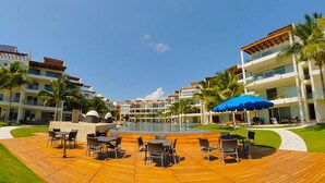 A resort with a pool, outdoor seating, and palm trees. - Elements GH18 by Tripintravel (Playa del Carmen)