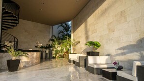 A modern lobby with a marble floor, a spiral staircase, and seating areas with potted plants. - Elements GH09 by Tripintravel (Playa del Carmen)
