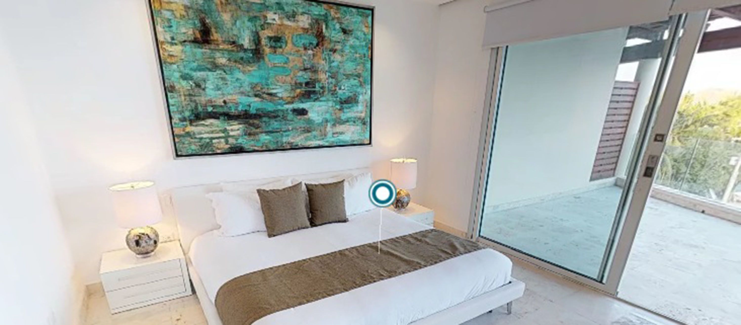 A modern bedroom with a large bed, a painting on the wall, and a view of the outdoors through a glass door.