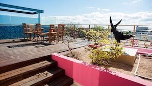 A wooden deck with outdoor seating and a sculpture.