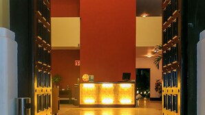 A reception area with a reception desk, a fire exit sign, and a potted plant. - Pueblito Luxury Penthouse by Tripintravel (Playa del Carmen)