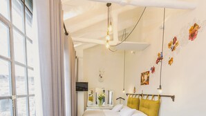 Una camera da letto moderna con un letto, un divano, un tavolino e una televisione.