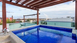 Une piscine à débordement située sur le toit, offrant une vue dégagée sur les toits de la ville.