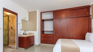 Ein Hotelzimmer mit Bett, Schminktisch, Dusche und Kleiderschrank.