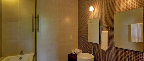 Un bagno moderno con doccia vetrata, una vasca da bagno ampia e un mobile lavabo con due lavandini.