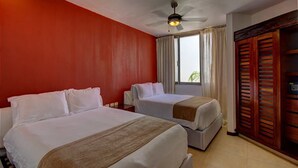 A hotel room with two beds, a ceiling fan, a window with curtains, and a wooden wardrobe. - Nolita 34 by Tripintravel (Playa del Carmen)
