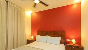 A bedroom with a bed, wooden headboard, nightstands, and a ceiling fan. - Nolita 31 by Tripintravel (Playa del Carmen)