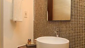 A bathroom with a white sink, a mirror, and a tiled wall. - Nolita 31 by Tripintravel (Playa del Carmen)