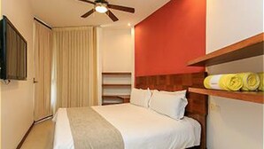 A bedroom with a bed, a ceiling fan, a wardrobe, and a shelf with towels. - Nolita 33 by Tripintravel (Playa del Carmen)