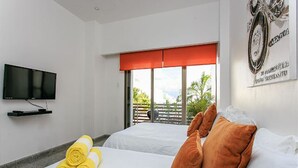 A hotel room with a bed, a TV mounted on the wall, and a window with a red blind. - Infinito 03 by Tripintravel (Playa del Carmen)