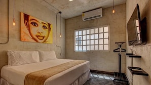 A bedroom with a bed, a window, an air conditioner, and a wall-mounted TV. - Charming Apt in Mamitas Beach by Tripintravel (Playa del Carmen)