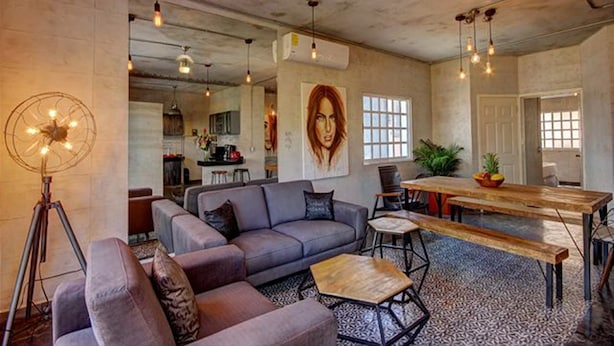 A modern living room with a gray sofa, a wooden coffee table, and pendant lights. - Charming Apt in Mamitas Beach by Tripintravel (Playa del Carmen)