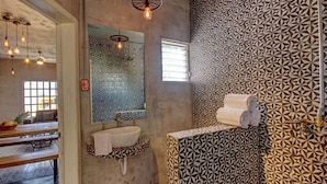 A bathroom with patterned walls, a sink, and a mirror. - Charming Apt in Mamitas Beach by Tripintravel (Playa del Carmen)
