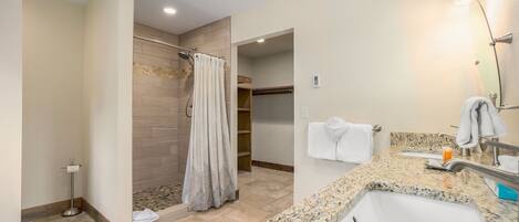 A modern bathroom with a shower, a sink, and a vanity.