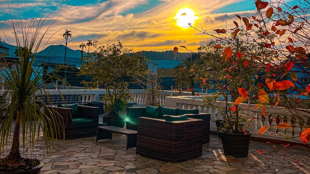 A patio area with stone flooring, outdoor furniture, and potted plants. - Parque Atlântico Hotel (Ubatuba)
