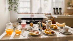 A breakfast table with various food items and drinks, a lace tablecloth, and a window with curtains in the background. - Parque Atlântico Hotel (Ubatuba)