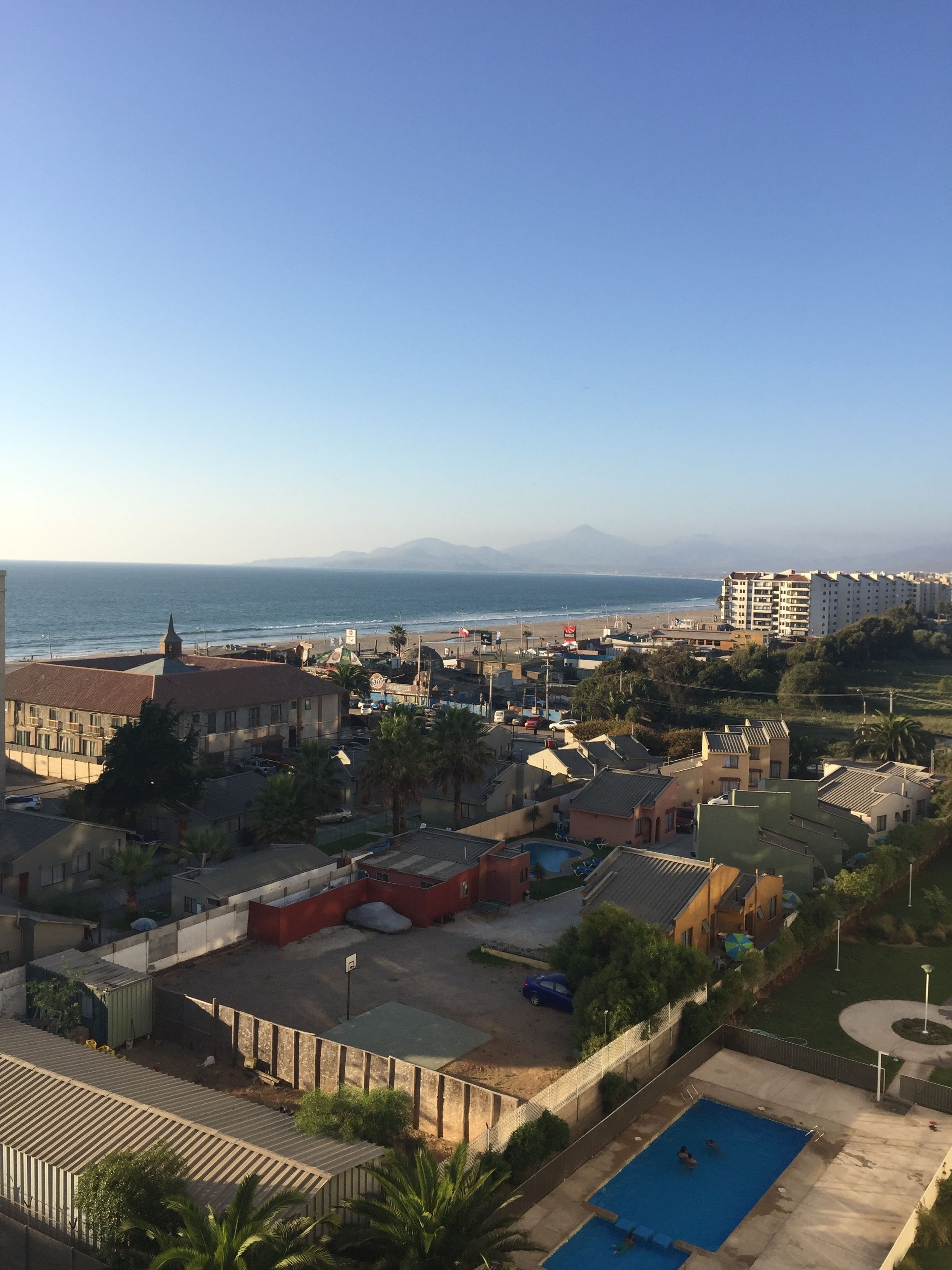 Un quartier résidentiel situé sur la côte, doté d’une piscine, d’une plage et offrant une vue sur les montagnes.