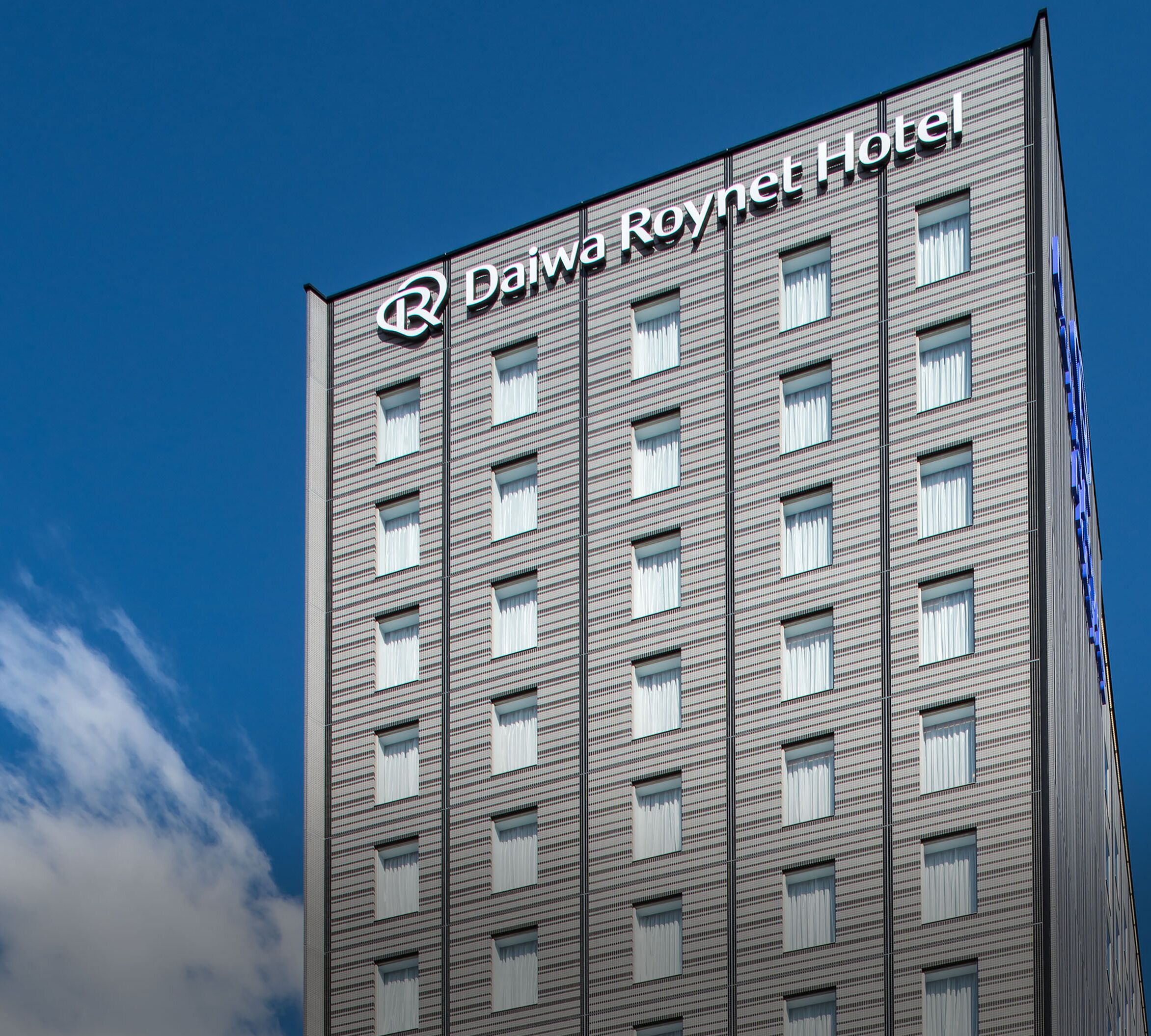 Un edificio de gran altura con el letrero "Daiwa Roynet Hotel" en la parte superior.