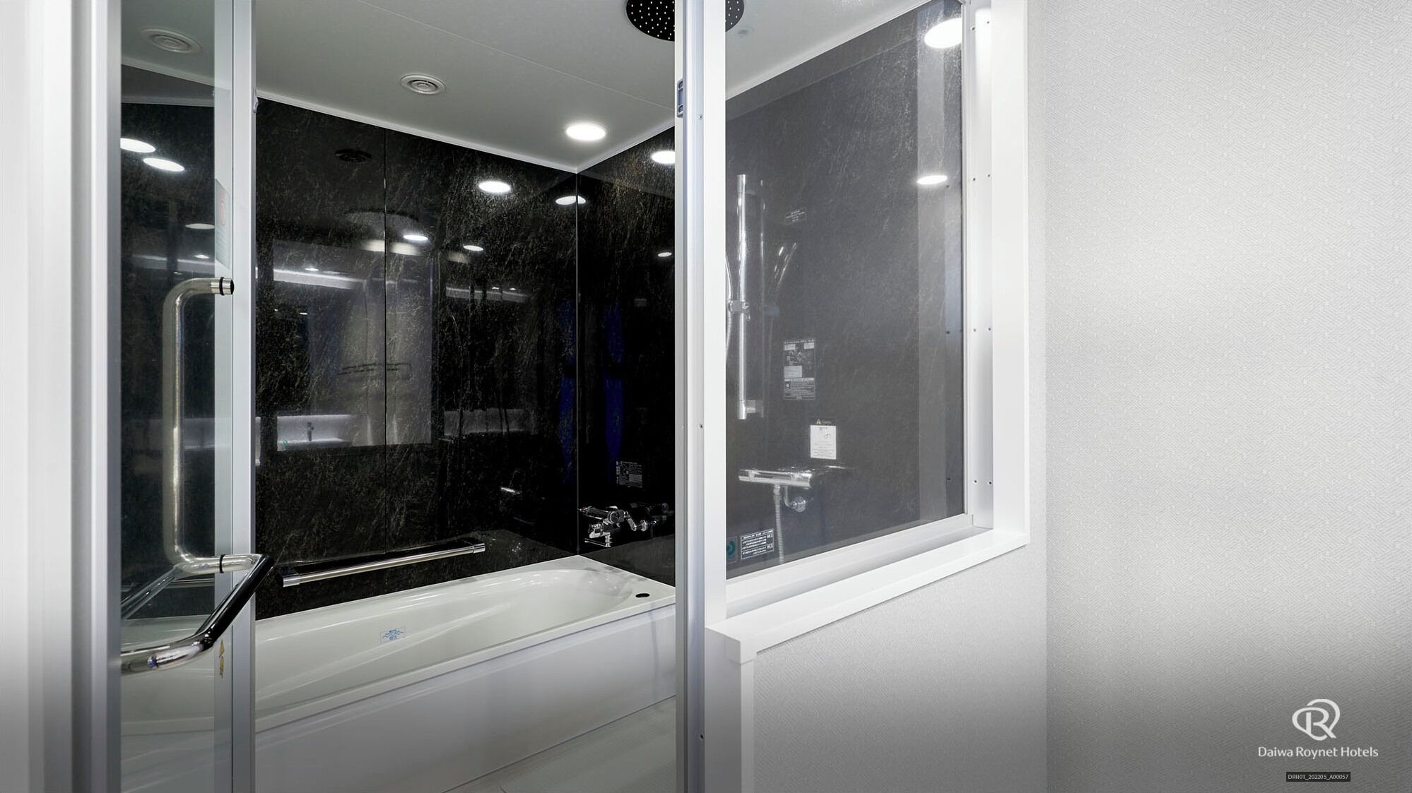 Un baño moderno con ducha envuelta en vidrio, bañera y retrete.