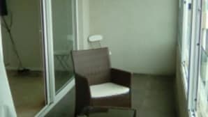 A narrow corridor with wicker furniture and a glass door leading to another room. - 47.- HNA Mirador El Faro (La Serena)