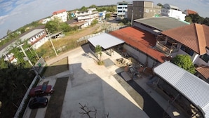 Vista aérea de una zona residencial con aparcamiento asfaltado, una bicicleta y algunos coches estacionados.