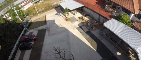 An aerial view of a residential area with a paved parking lot, a bicycle, and a few cars parked.