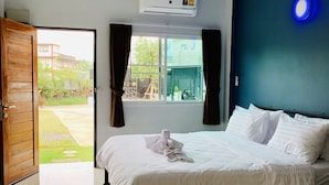 Una habitación de hotel con una cama, una ventana con cortinas, un equipo de aire acondicionado y una luz azul en la pared.