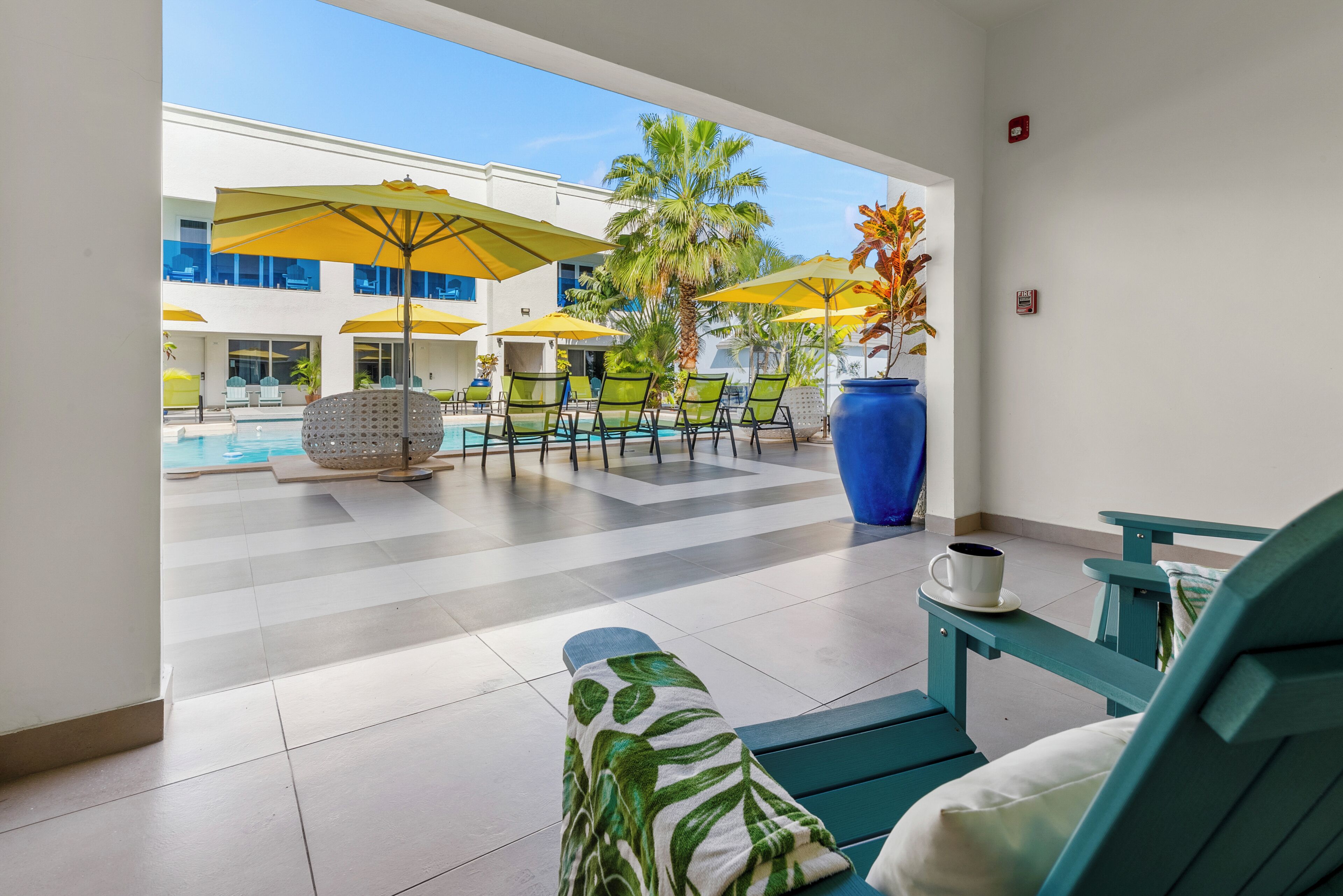 Un espace aménagé au bord de la piscine, avec des chaises longues, des parasols et une table basse.