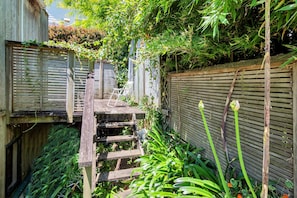 Escape to a serene garden oasis with a wooden staircase leading to a secluded platform.