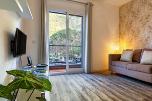 Lägenhet Deluxe - 1 sovrum - uteplats | Vardagsrum | 55-tums platt-tv med kabelkanaler och tv