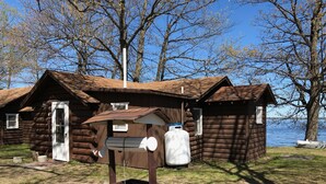 Une cabane rustique avec une porte en bois et une boîte aux lettres.