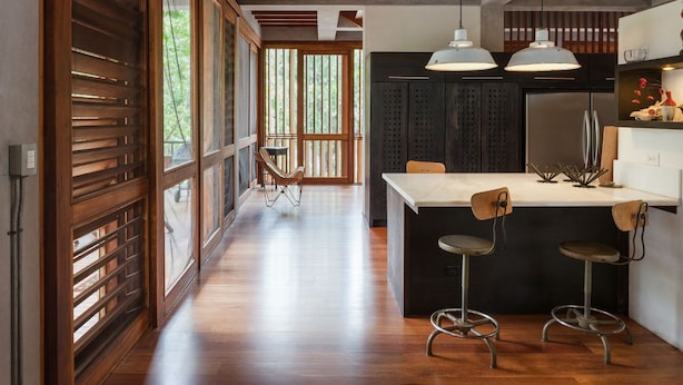 A modern kitchen with a central island, pendant lighting, and a view of the outdoors through large windows. - BirdHouse@Gamboa, Panama Canal (Gamboa)