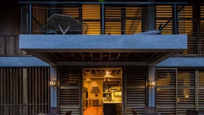 A modern building with a wooden deck, outdoor seating, and a visible kitchen area. - BirdHouse@Gamboa, Panama Canal (Gamboa)