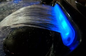 A close-up of a water spout with a blue light.