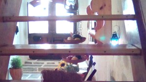 Una scala in legno con vista su un angolo cottura sottostante, che include un lavello, una ciotola di frutta e una pianta in vaso.