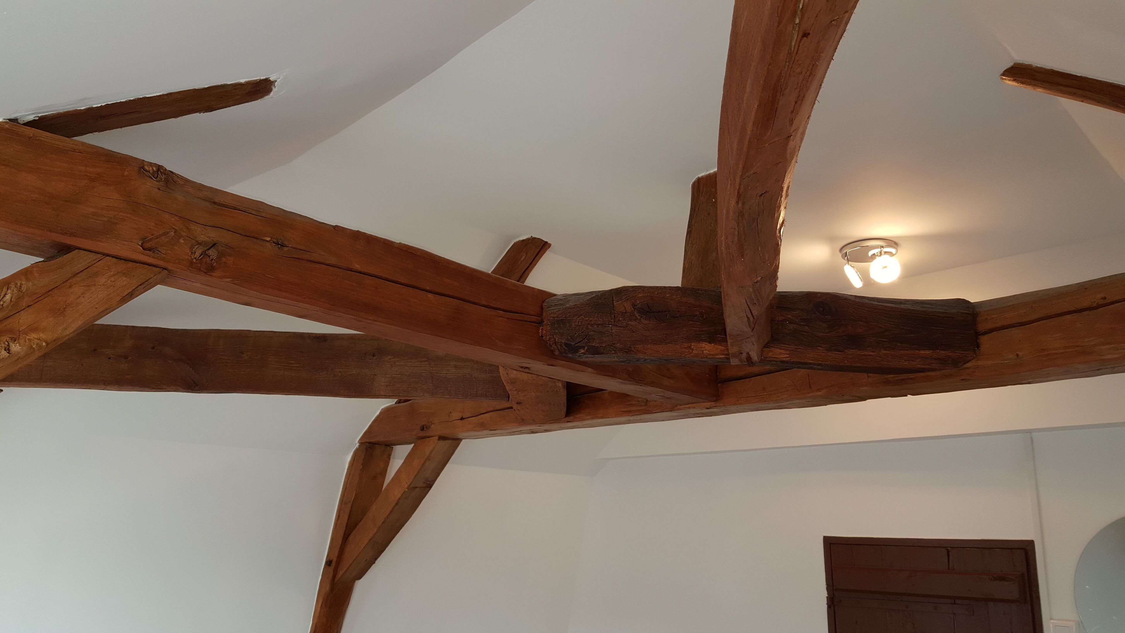 A room with exposed wooden beams and a white ceiling.