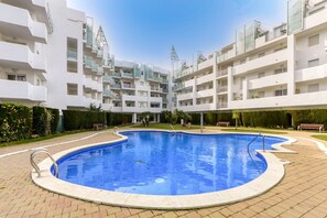 A modern apartment building with a central swimming pool surrounded by a paved area. - ROYAL MARINE 222 Roses (Rosas / Roses)