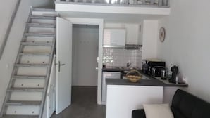 A compact kitchen with white cabinets, a stainless steel sink, and a coffee maker. A staircase leads to a door at the top. - BANDOL - Seaside - Beautiful Apartment - all Comfort - Air Conditioning-Wifi... (Bandol)
