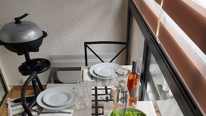 A dining table set with white plates, glasses, and cutlery, a bowl of salad, and a bottle of water. - BANDOL - Seaside - Beautiful Apartment - all Comfort - Air Conditioning-Wifi... (Bandol)