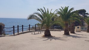 A coastal promenade with palm trees, a bench, and a view of the sea. - BANDOL - Seaside - Beautiful Apartment - all Comfort - Air Conditioning-Wifi... (Bandol)